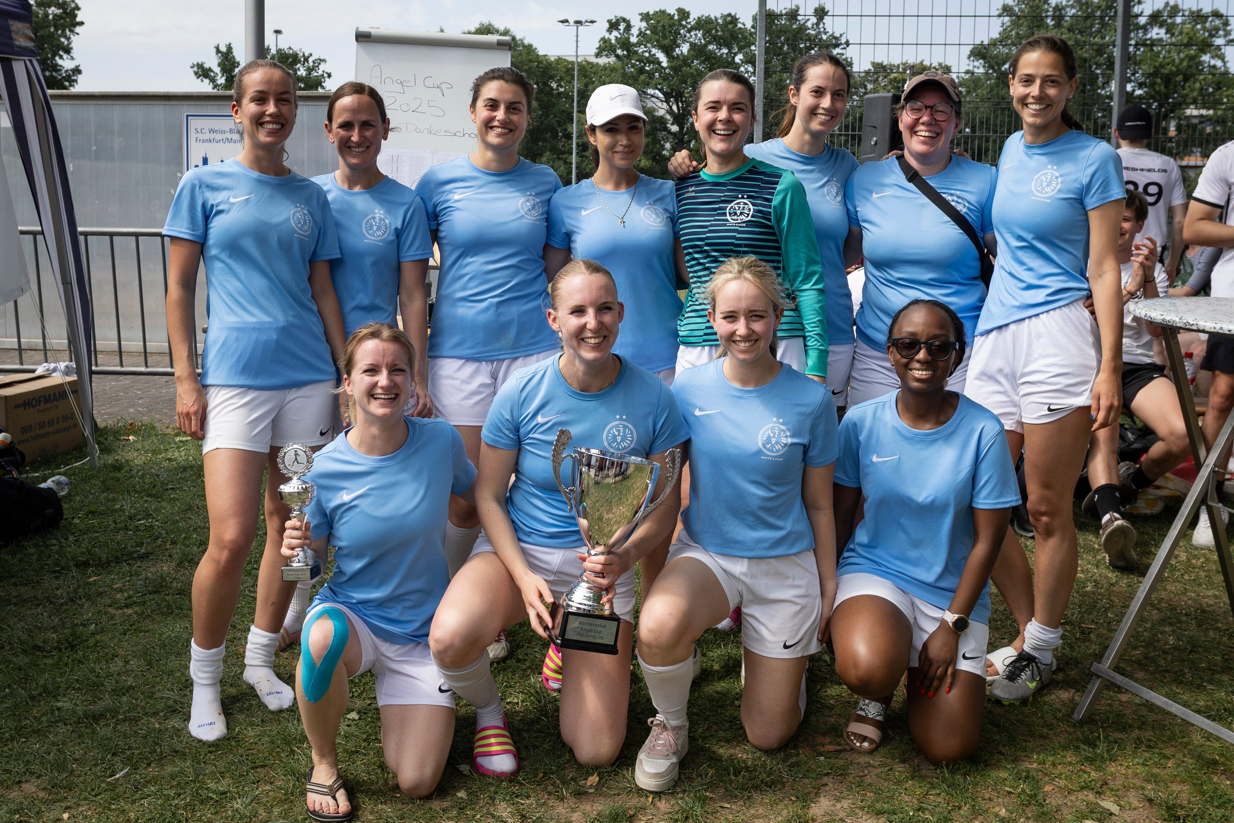 Das Damenfußball-Team von White & Case mit dem Pokal für den 1. Platz