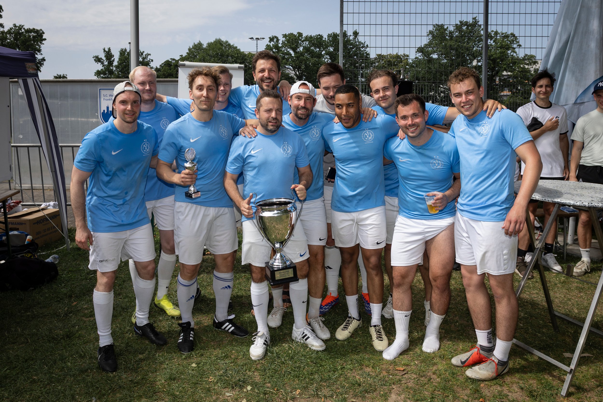 Das Herrenfußball-Team von White & Case mit dem Pokal für den 1. Platz