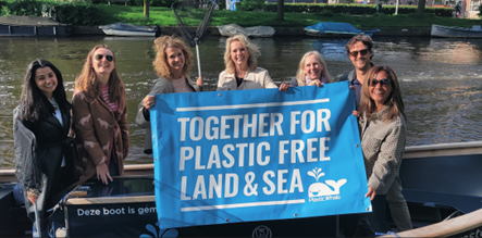 Team holding Plastic Whale Foundation flag